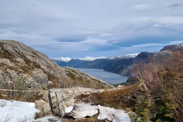Utsikt utover fjorden, med vann og snø i forgrunn